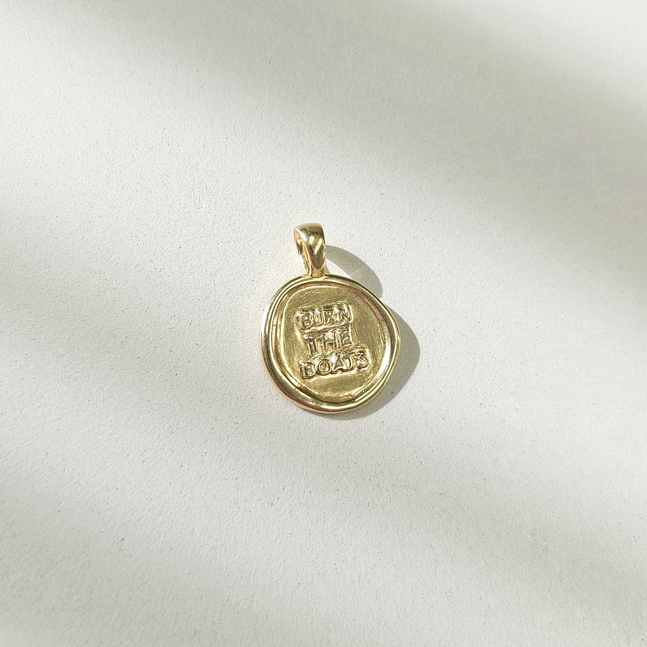 Top View of charm: Burn the Boats Motivational Charm Pendant Jewelry in Gold by Lat & Lo- Wax seal-Coin shaped jewelry-gift jewelry-inspiring necklace charm