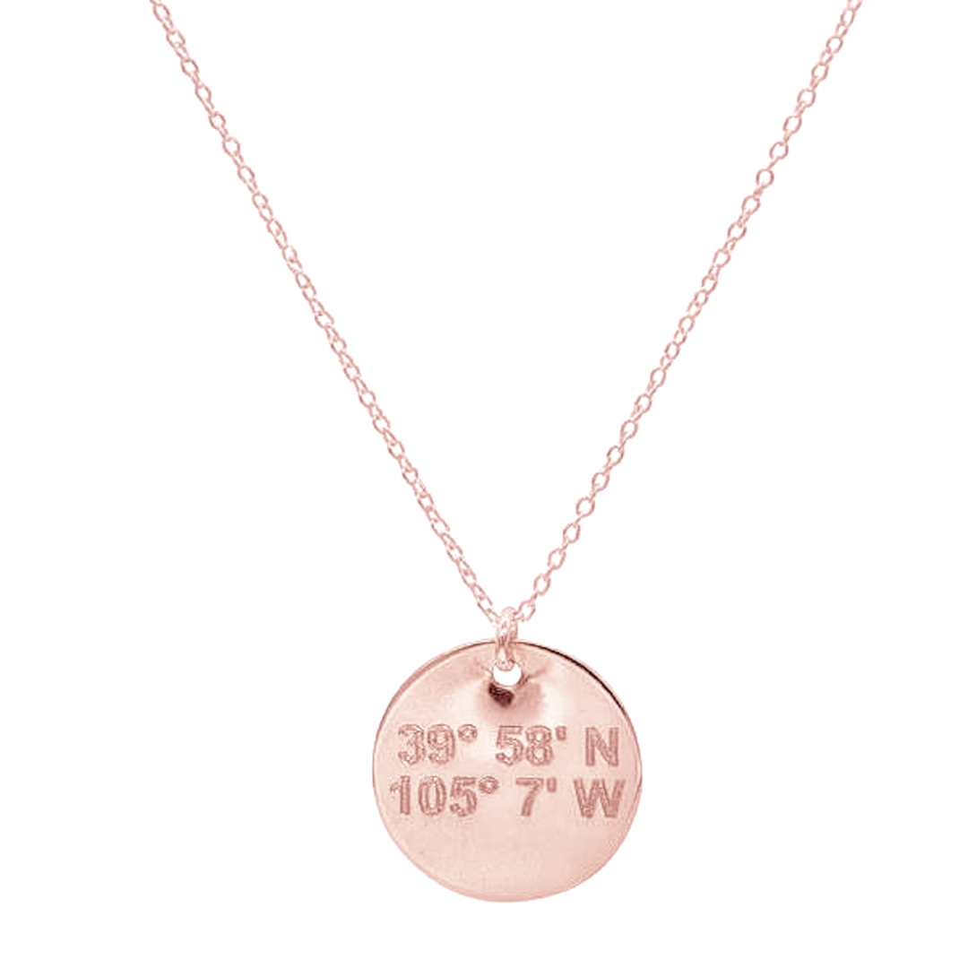 Lat & Lo disc necklace in rose gold inscribed with custom coordinates.