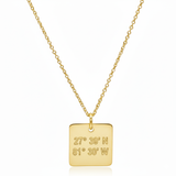 Gold necklace with a square pendant displaying coordinates on a white background