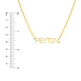 Gold custom name pendant necklace with a ruler for scale on a white background