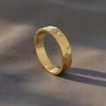 Gold ring with a textured surface on a gray background