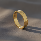Gold ring with a textured surface on a gray background