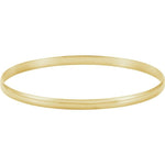 A thin, polished yellow gold bangle bracelet shown against a plain white background.