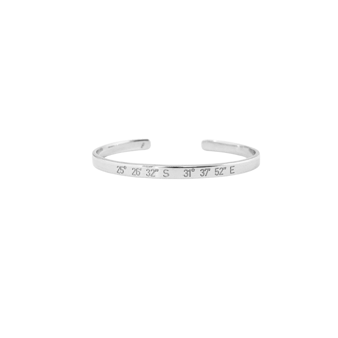 Silver bracelet with engraved coordinates on a white background