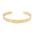 Gold bracelet with engraved measurements on a white background