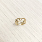 gold cut-out-style coordinates ring on table top view-lat & lo personalized jewlery collection