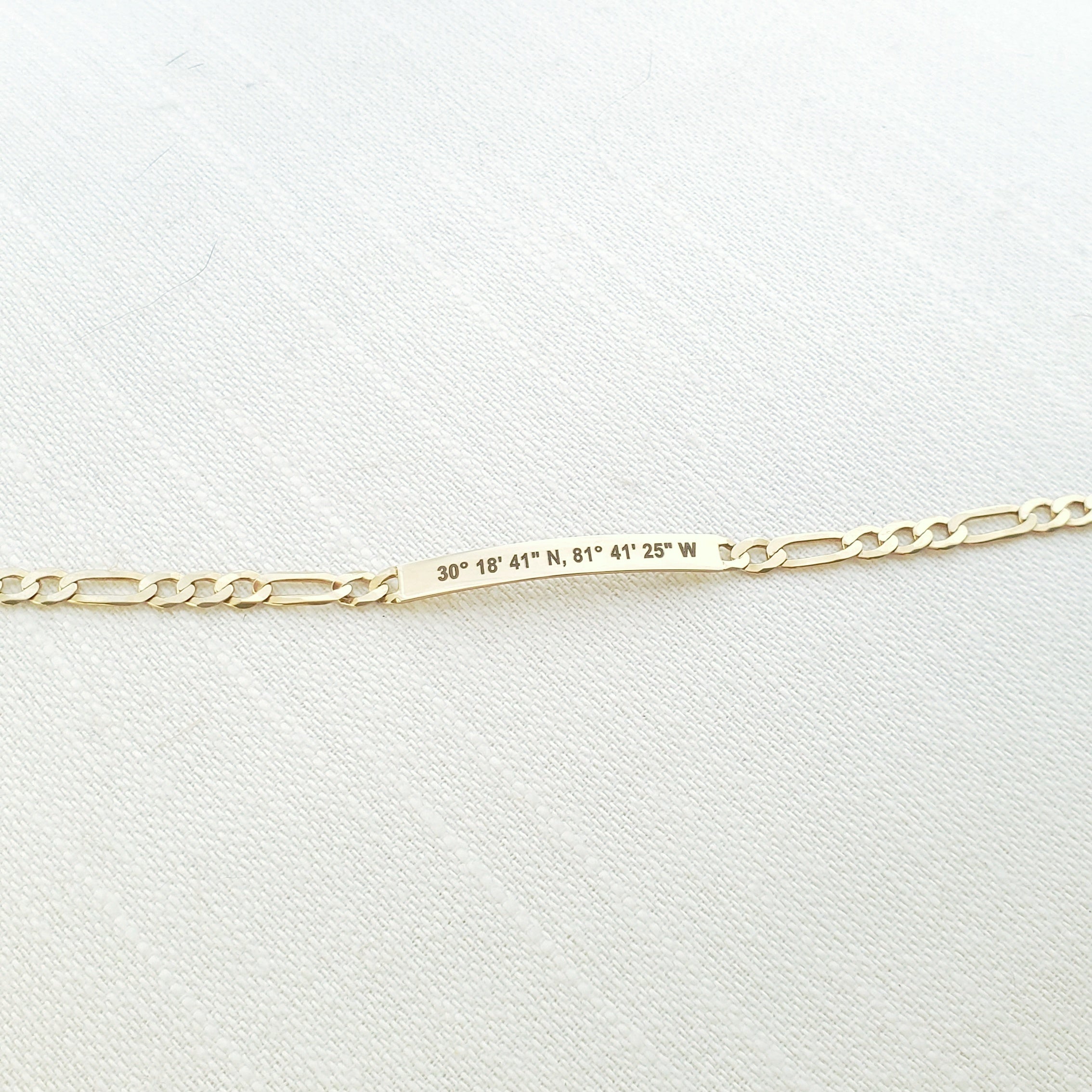 Lat & Lo Co-Captains bracelet laying flat, women's style, figaro chain, engraved with coordinates, gold vermeil
