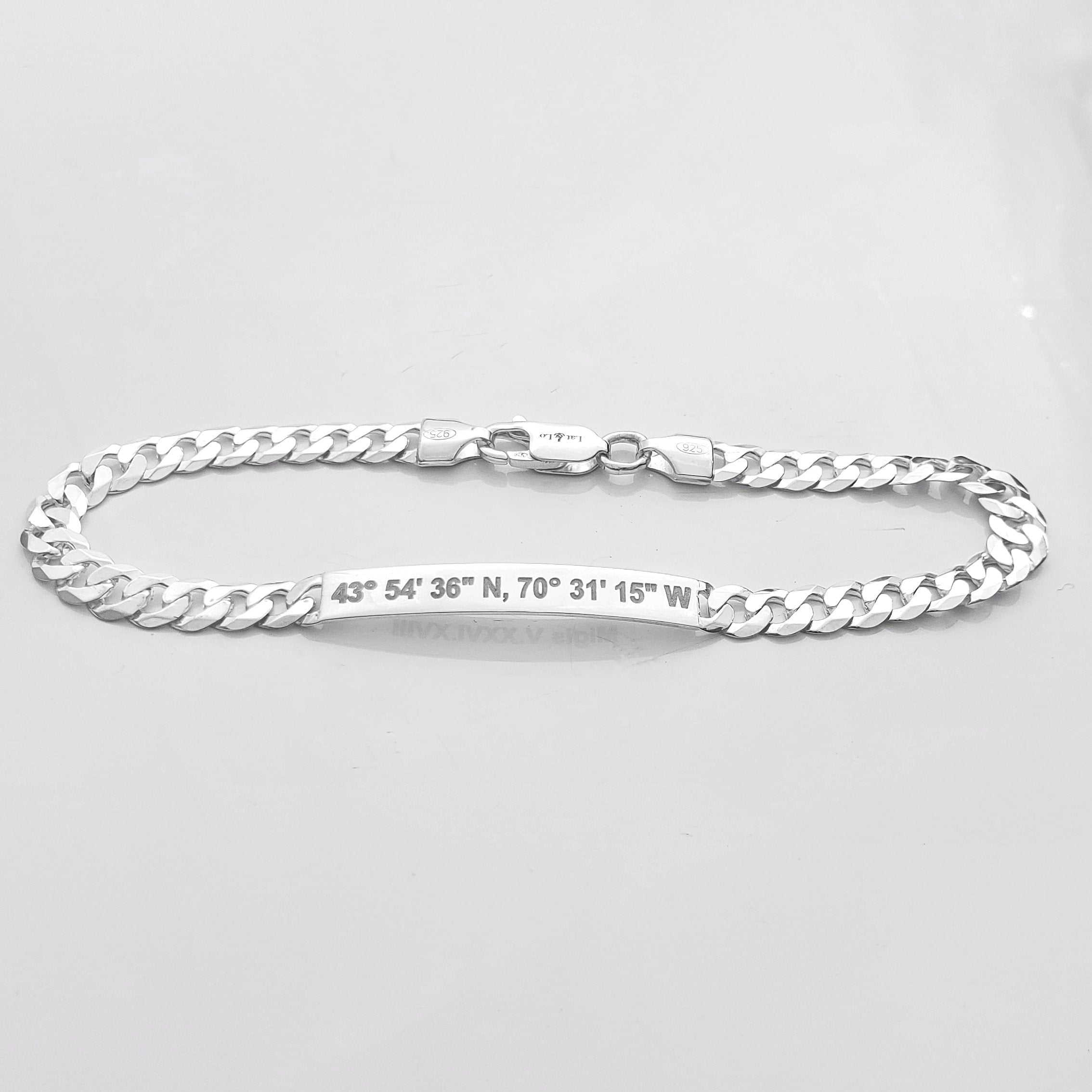 Sterling silver coordinates bracelet for men inscribed with latitude longitude coordinates on the front. lobster clasp. Closeup picture of the bar and the chain.By Lat & Lo. Origins bracelet.