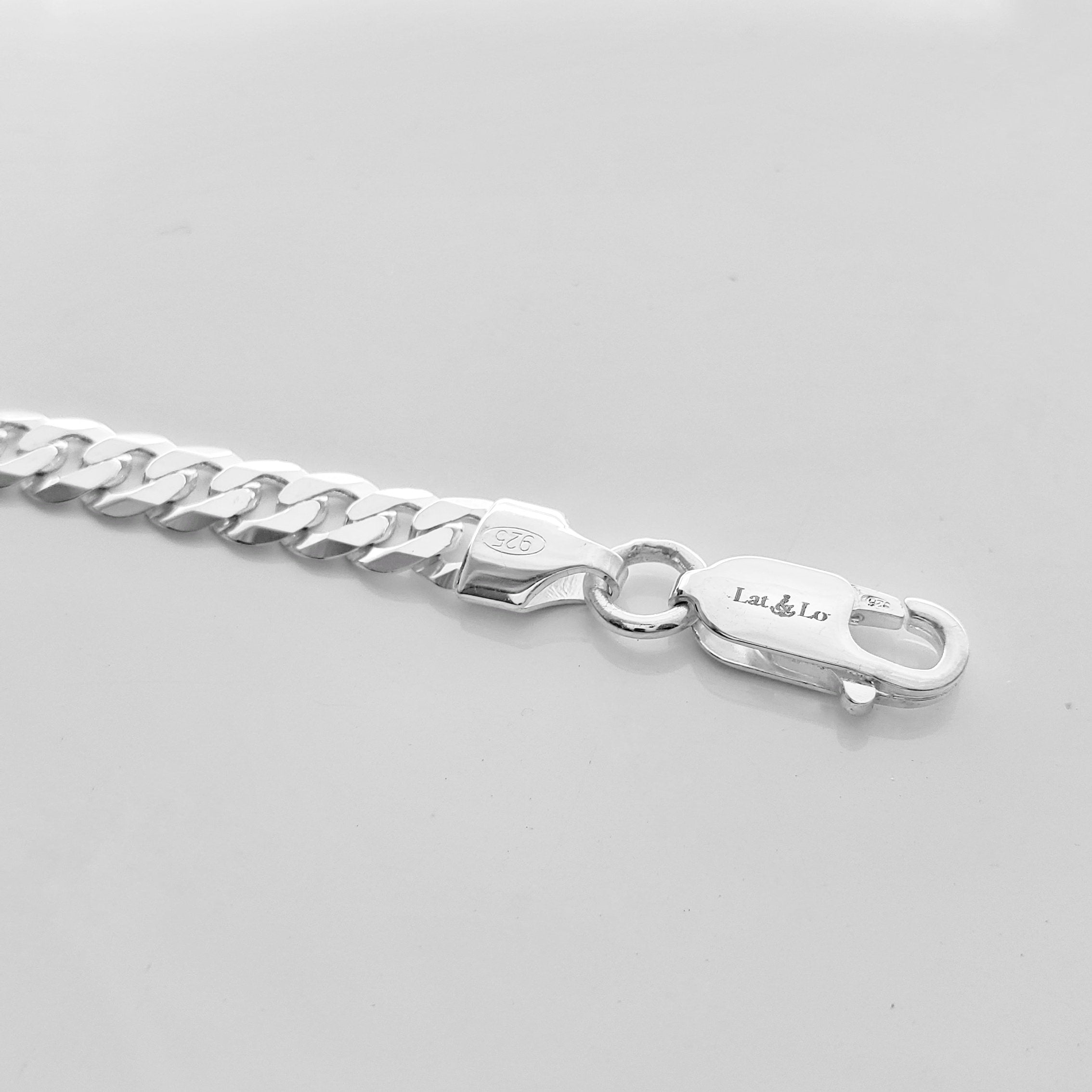 Sterling silver coordinates bracelet for men inscribed with latitude longitude coordinates on the front. lobster clasp. Closeup picture of the bar and the chain.By Lat & Lo. Origins bracelet.