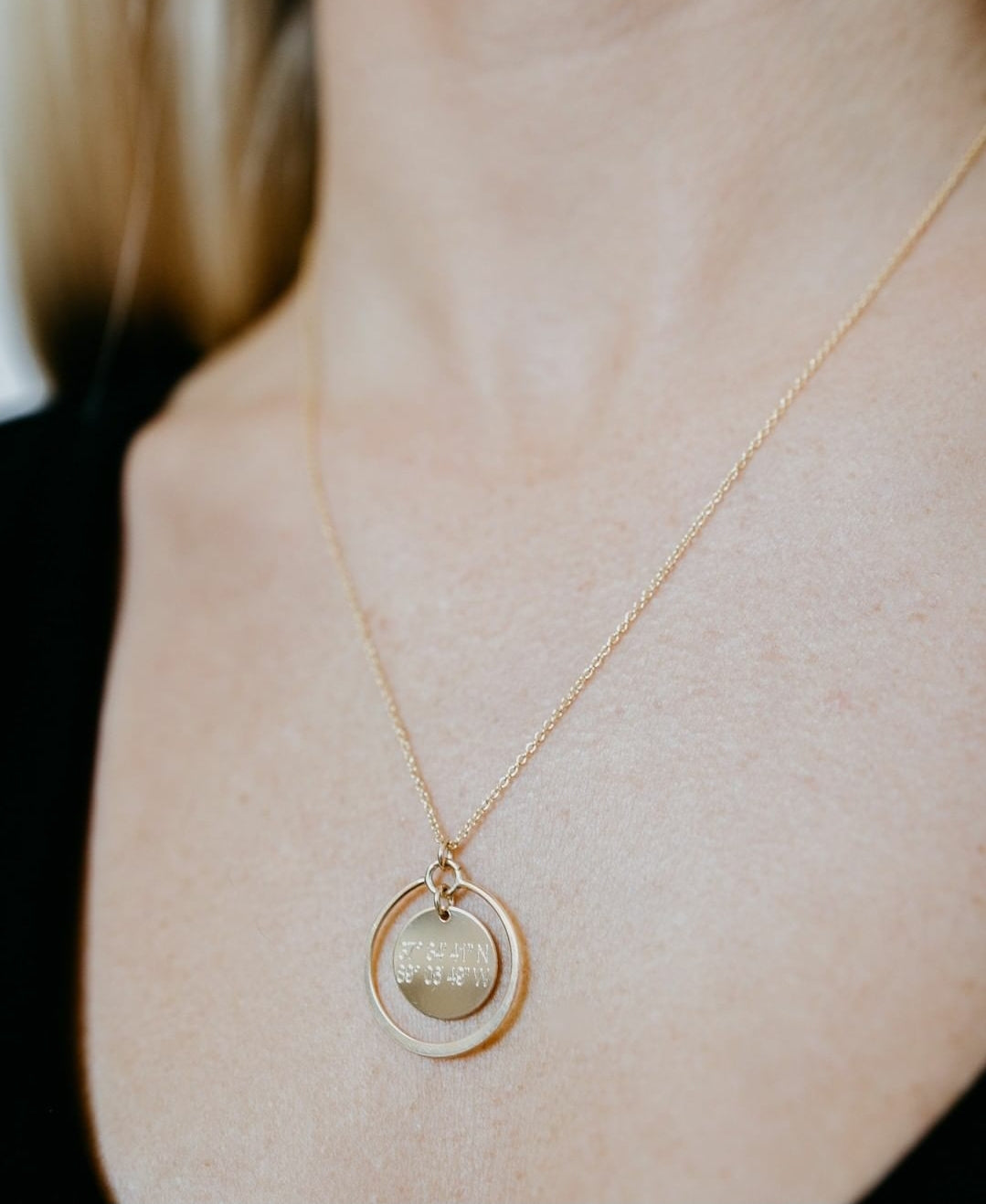 Lat & Lo eclipse necklace, inscribed with coordinates, 14K gold filled, 13mm charm with halo ring surrounding, on figure