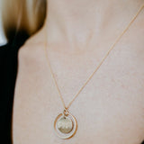 Lat & Lo eclipse necklace, inscribed with coordinates, 14K gold filled, 13mm charm with halo ring surrounding, on figure
