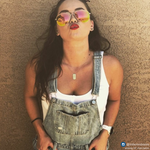Lat & Lo mini dog tag custom inscribed with coordinates on girl wear sunglasses and overalls.