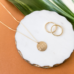 Lat & Lo disc necklace inscribed with custom coordinates picture with two Journey rings.